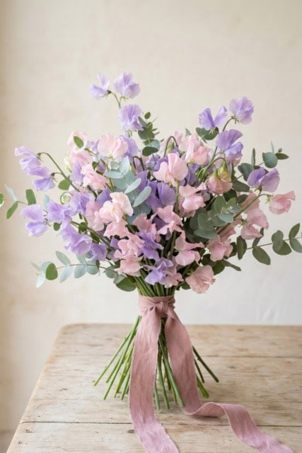 Hand-tied sweet pea floral arrangement in pastel colors with ribbon